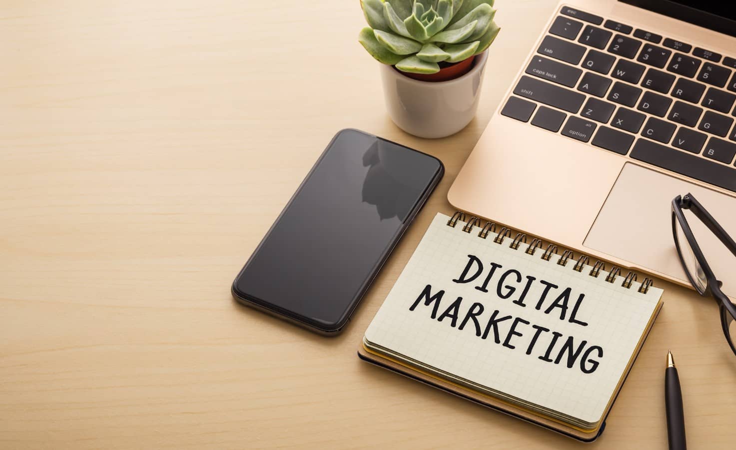 Desk with laptop, phone and notebook